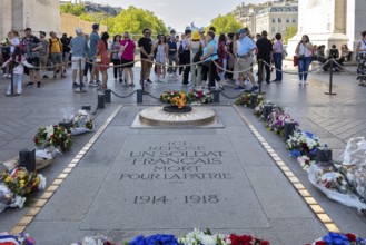 Monument with floral wreaths and people in honour of a fallen soldier in Paris, Paris