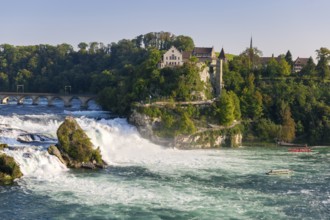 Picturesque landscape with a waterfall, river, bridge and buildings, all in a warm afternoon light,