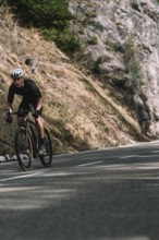 Road bike rider in spring in the Allgäu against the picturesque backdrop of the Alps, Bavaria,