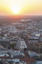 View of the city from the City Tower at sunset, St Thomas' Church, Red Bull Arena and Auwald