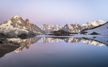 Evening mood with pink evening sky, mountain landscape at sunset, water reflection in Lac Blanc,