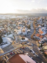 Town with snow-covered roofs and a central roundabout in winter light, Calw- Stammheim, Black