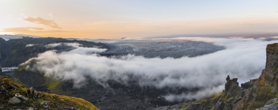 Fog between the cliffs, clouds moving around, glacier ice of the Kötlujökull glacier tongue at