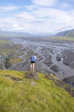 Hiker, Young woman on a hill, view over alluvial land, meandering river, Dímonarhellir, Suðurland,