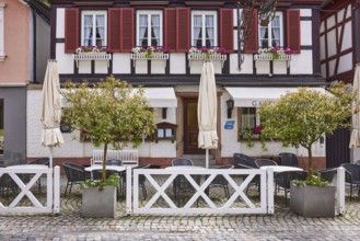 Outdoor area with tables and chairs, planters, half-timbered house, Gasthaus Hotel Hecht, main