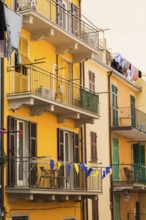 Yellow and beige stucco cladded residential apartment building facade and washed clothes drying on