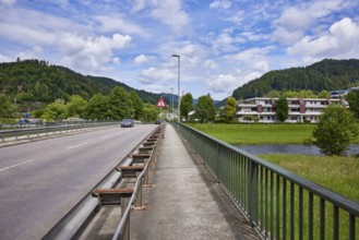 River Kinzig, car and pedestrian bridge, lantern, residential building, hill with coniferous