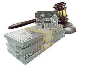 Miniature house with stack of money and wooden gavel isolated on a white background