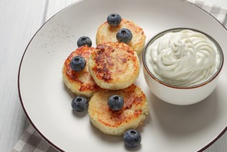 Cottage cheese pancakes, with blueberries, breakfast, on a white wooden table, no people, top view