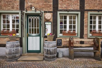 Entrance area of a restaurant in a historic half-timbered brick house with entrance door, white