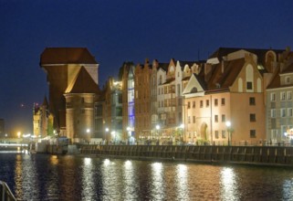 The crane gate, left, with its striking shape, built of brick and wood, in the evening-lit harbour