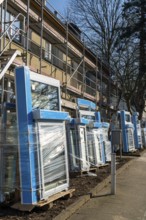 Energy-efficient refurbishment of residential buildings, older apartment block is scaffolded, gets