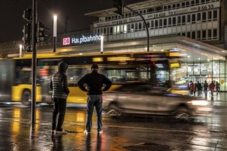 Passers-by at a pedestrian crossing, at the main railway station, rainy weather, city centre, in