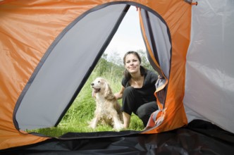 Woman Looking Inside a Camping Tent with Her Cocker Spaniel Dog in Switzerland