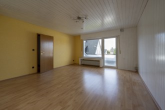 Renovated room in an old building without furniture, white ceiling panels and wall panels, floor