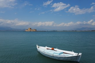 A small fishing boat in calm waters with an island in the background, Fortress, Bourtz Island,