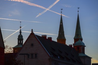 Silhouettes of the towers of St Sebald's Church in the old Wolf Town Hall, evening sky with