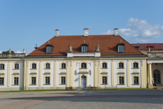 Baroque building with red tiled roof and classicist windows under a blue sky, Branicki Palace,