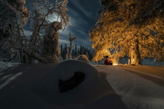 Man in the evening at a bivouac with campfire, Lapland, Sweden, Scandinavia, Europe