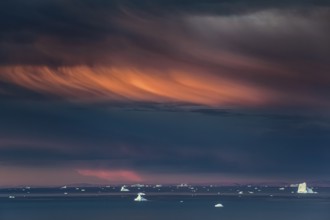 Evening light and atmosphere in fjord with icebergs, cloudy, autumn, Scoresby Sund, East Greenland,