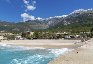 Tourist development construction building work view from Drymades beach to Mount Cika snow capped