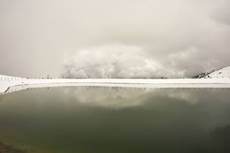 Onset of winter in May, Riezler Alpsee, an artificial lake, snow pond, feeds the snow cannons that