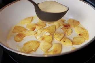 Swabian cuisine, preparation fry apple pieces, put raw dough in pan, soup ladle, pancake with