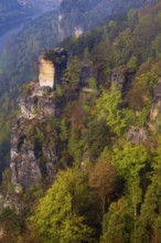 The bright lit Wartturm above the Elbe river seen from the Bastei rocks near the village of Rathen