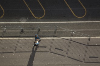 Top view of two middle aged women walking along a asphalt road surface in the port of La Spezia,