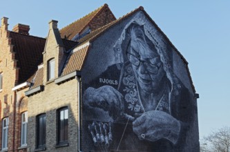 Mural lace maker with traditional lace bonnet, realistic mural in black and white by street artist