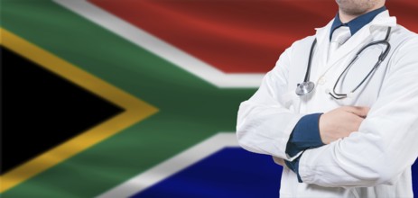 South Africa Health and Care concept. Male doctor on South Africa flag. Doctor with crossed arms on