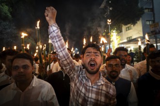 Members of the All Assam Students' Union (AASU) take part in a flaming torch rally and shout