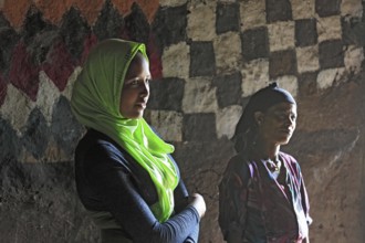 Mother and daughter with headscarf in their round hut in the south of the country, Ethiopia, Africa