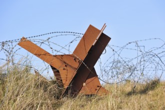 Barbed wire and Czech hedgehog static anti-tank defences from the Second World War on a beach in