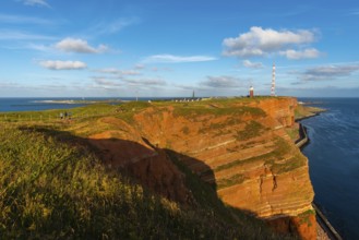 Red mottled sandstone cliff edge, Heligoland high sea island, North Sea, grass, lighthouse, radio