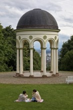 Couple in the park in front of the Monopteros, round building with columns, on the Neroberg, a