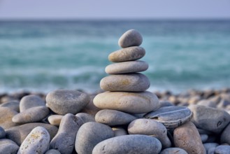 Zen meditation relaxation concept background, balanced stones stack close up on sea beach