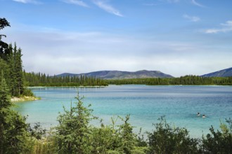 Transparent clear lake and two people in the water, tourism, Boya Provincial Park, Stewart Cessiar