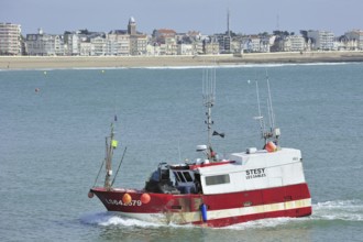 Fishing boat and apartments along the coastline at Les Sables-d'Olonne, La Vendée, Pays de la