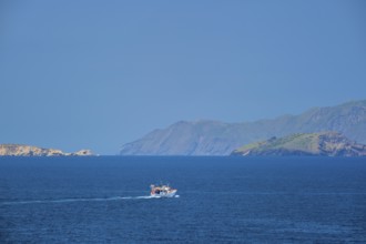 Greek fishing boat in blue waters of Aegean sea near Milos island, Greece, Europe