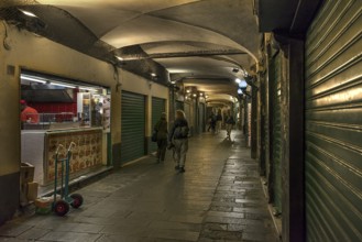 Closed shops in the old arcades at the harbour at night, Genoa, Italy, Europe