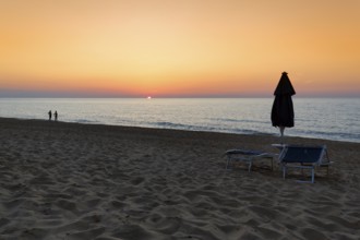 Two tourists, couple enjoying sunset at the sea, sandy beach, backlight, Spiaggia di Scivu, Arbus,