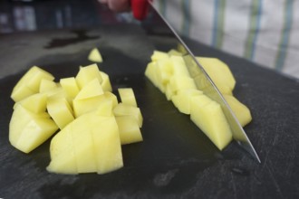 Preparation of a cress soup, cutting raw potatoes, cutting board, kitchen knife, chopping, Swabian