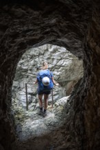 Hiker in a tunnel, Hammersbach flows through Höllentalklamm, near Garmisch-Partenkirchen,