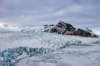 Snow-covered icebergs in the Fjallsarlon glacier lagoon, with the Öraefajökull glacier behind,