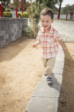 Young chinese and caucasian boy having fun at the park