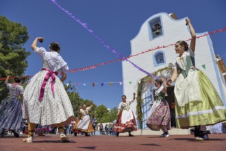 Women in traditional dress dance in front of the Ermita de San Vicent chapel, annual fiesta in