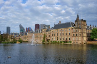 View of the Binnenhof House of Parliament and the Hofvijver lake with downtown skyscrapers in