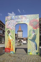 View to the historic Obertorturm through the main street with a poster and inscription to