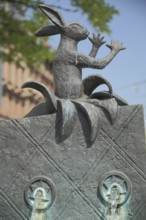 Figure with rabbit and gesture with arms at the Struwwelpeter fountain, humour, Hauptwache, city